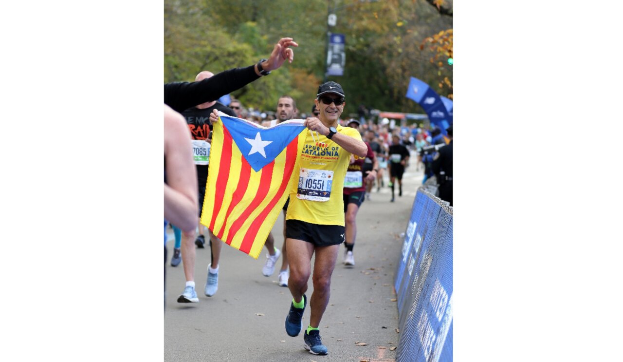 Arcadi Alibés corrent amb una bandera estelada durant una marató.