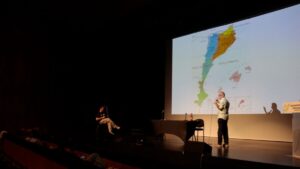 El professor de la Universitat Rovira i Virgili, Pere Navarro, durant la conferència sobre el mapa dialectal del català (Ariadna Escoda, ACN)